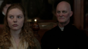 Laoghaire and Father Bain at the trial - from Outlander-Online.com